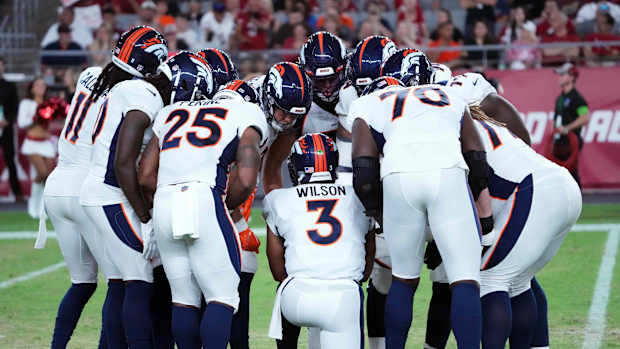 Denver Broncos quarterback Russell Wilson (3) huddles teammates against the Arizona Cardinals during the first half at State Farm Stadium.